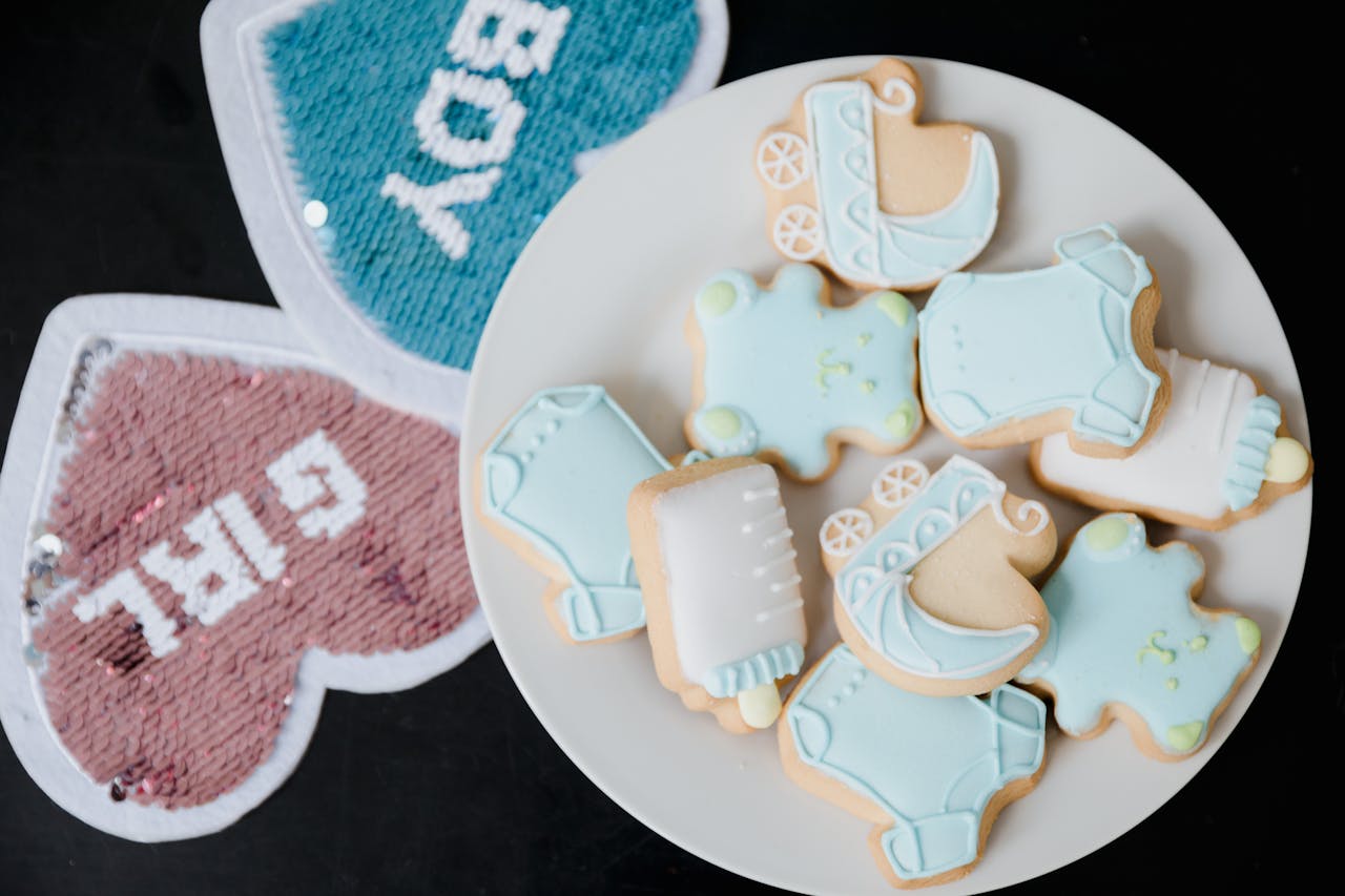 Plate of gender reveal cookies decorated with pastel blue icing for a baby shower.